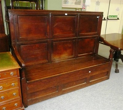 Lot 562 - An 18th century oak settle with high panelled back and hinged seat