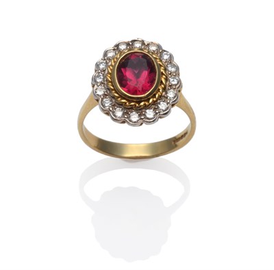 Lot 189 - An 18 Carat Gold Pink Tourmaline and Diamond Cluster Ring, the oval cut pink tourmaline in a yellow