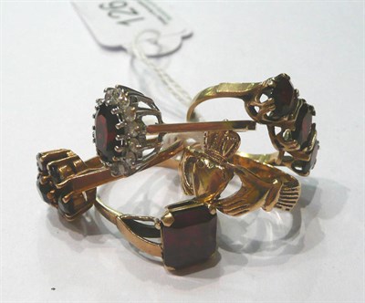 Lot 126 - Three 9ct gold garnet rings, a 9ct gold Claddagh ring and a 9ct gold red stone ring
