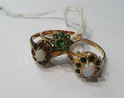 Lot 127 - A 9ct gold opal and garnet cluster ring, a 9ct gold opal and sapphire ring and a 9ct gold...