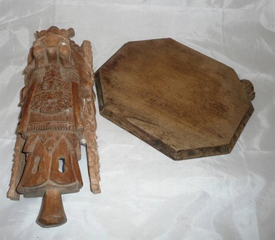 Lot 192 - An early 20th century oak cheeseboard carved with a mouse and a Balinese mask