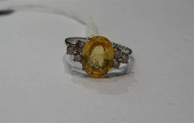 Lot 260 - A 14ct white gold yellow sapphire and diamond ring