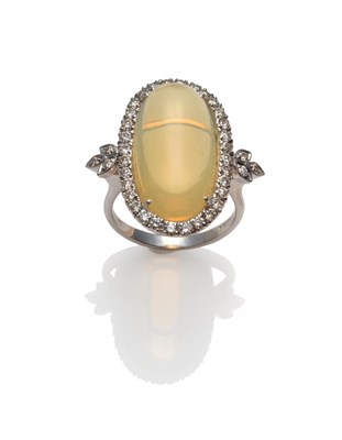 Lot 227 - An 18 Carat White Gold Opal and Diamond Cluster Ring, an oval cabochon opal within a border of...