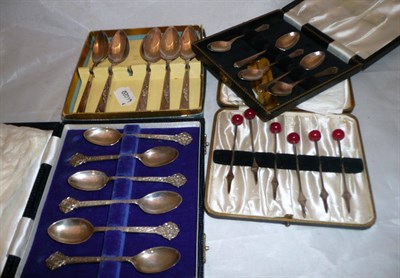 Lot 341 - Two cased sets of silver coffee spoons and a cased set of silver cocktail sticks, 5.27oz total;...