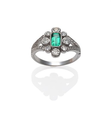 Lot 230 - An Emerald and Diamond Cluster Ring, the emerald-cut emerald in a spaced border of old cut...