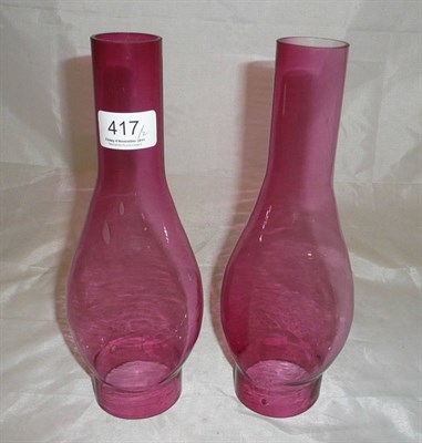 Lot 417 - A pair of cranberry glass oil lamp chimneys