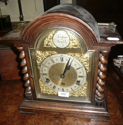 Lot 486 - A chiming table clock in an oak case