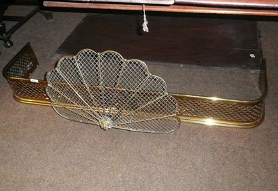 Lot 621 - Brass fender, brass fan shaped clip-on spark guard, a brass poker and matching toasting fork