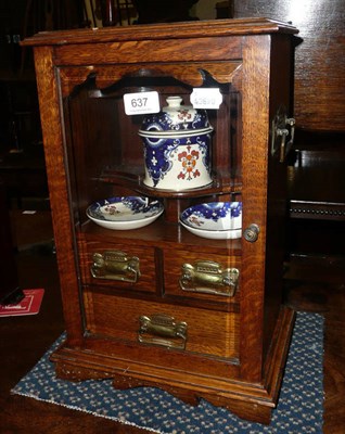 Lot 637 - An Edwardian oak smokers cabinet