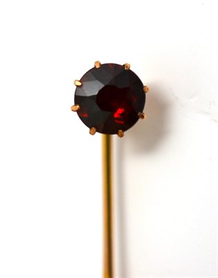 Lot 262 - A Stick Pin, in a Wartski case, a round cut garnet in a yellow claw setting, on a pin with...