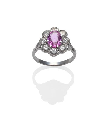Lot 265 - A Pink Sapphire and Diamond Cluster Ring, the oval mixed cut pink sapphire within a border of round