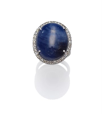 Lot 273 - An 18 Carat White Gold Sapphire and Diamond Cluster Ring, the large cabochon sapphire within a...