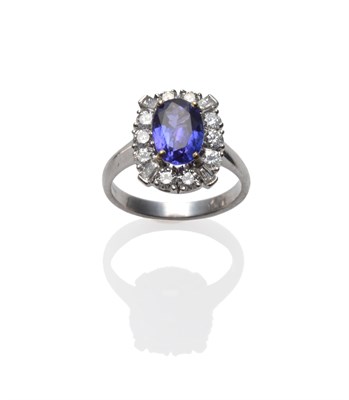 Lot 277 - An 18 Carat White Gold Tanzanite and Diamond Cluster Ring, the oval cut tanzanite within a...