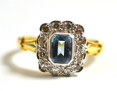 Lot 278 - An 18 Carat Gold Aquamarine and Diamond Cluster Ring, the emerald-cut aquamarine within a border of