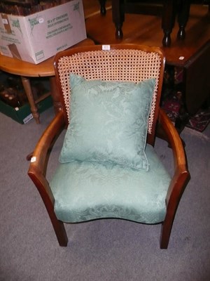 Lot 873 - A beech open arm chair with cane back green upholstered seat and loose cushion