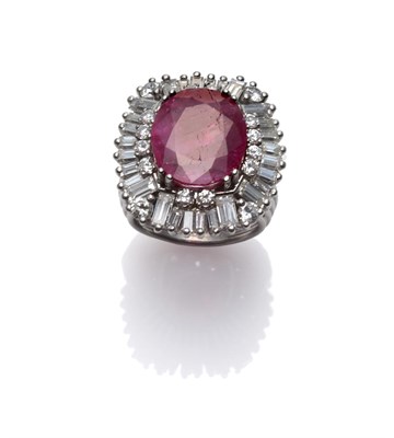 Lot 285 - A Ruby and Diamond Cluster Ring, the oval cut ruby within a border of round brilliant and...