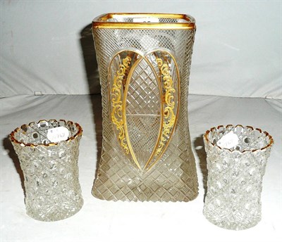 Lot 35 - A cut glass and gilt square section vase and a pair of cut glass and gilt vases