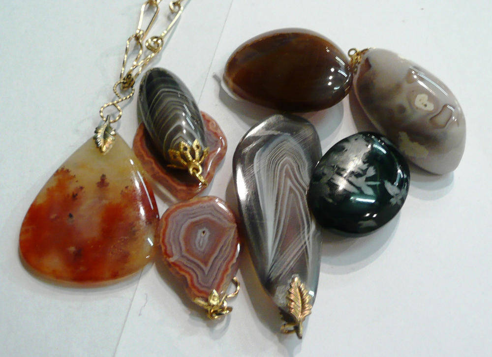 Lot 124 - A moss agate pendant on chain, four agate pendants and two brooches