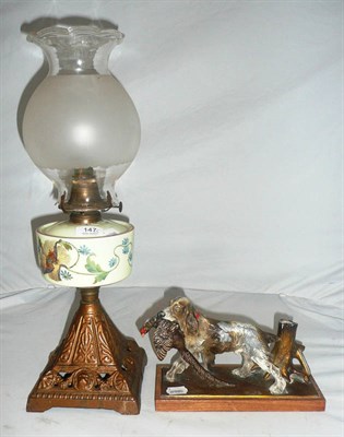 Lot 147 - Oil lamp and a spelter spaniel lighter