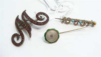 Lot 376 - A garnet-set initial 'M' brooch, a turquoise and seed pearl date brooch and an enamelled pin