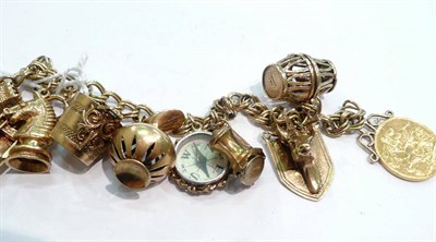 Lot 393 - A charm bracelet hung with eight gold charms, another and a 1925 soldered sovereign