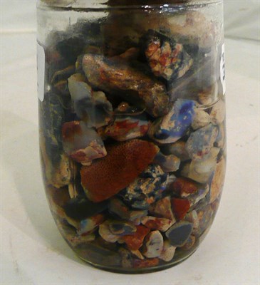 Lot 434 - A jar of rough opals (and possibly other stones) in water