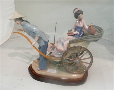 Lot 528 - A Lladro group depicting an Oriental lady in a carriage on a plinth base