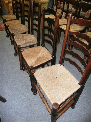 Lot 702 - Six oak ladder-back rush-seated chairs