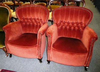 Lot 708 - A pair of early 20th century upholstered tub shaped chairs with button backs