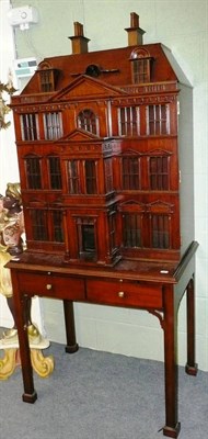 Lot 786 - A drinks cabinet as a doll's house with opening front, on mahogany table