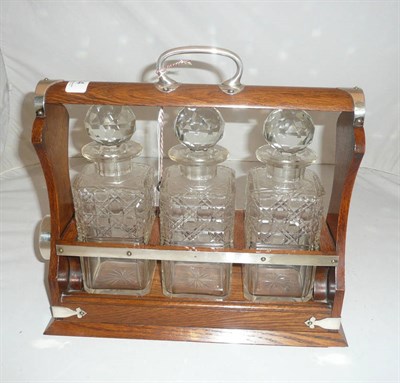 Lot 14 - Late Victorian oak and silver plated three bottle Tantalus by Walker & Hall, with key