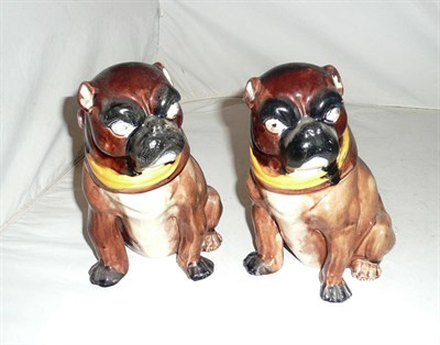 Lot 24 - A pair of Majolica pug dog tobacco jars and covers