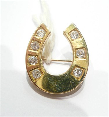 Lot 56 - A diamond set horseshoe brooch, seven old cut diamonds set into a plain polished yellow gold mount