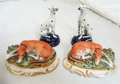 Lot 110 - A pair of Staffordshire pottery greyhounds and a pair of dalmatians (4)