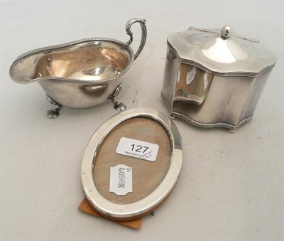 Lot 127 - Silver oval photo frame, silver sauce boat and a white metal tea caddy