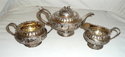 Lot 163 - A Georgian silver three piece tea service with repouse decoration, 47oz