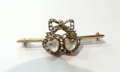 Lot 191 - A moonstone and rose cut diamond twin heart and bow on a bar brooch