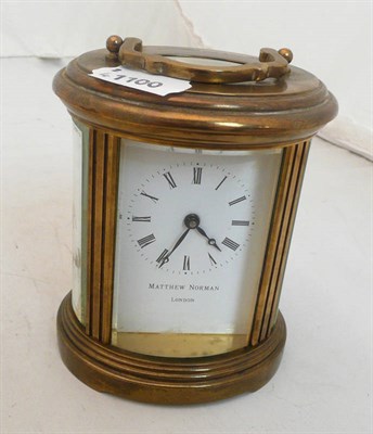 Lot 334 - Brass oval cased carriage clock by Matthew Norman (in original case with key)