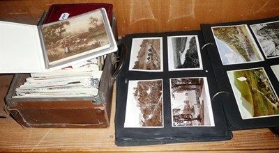 Lot 343 - A small suitcase of postcards and a scrap album with postcards