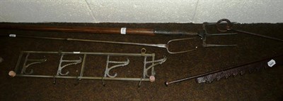 Lot 356 - A brass wall mounted coat rack, a hay fork, a steel log fork etc