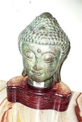 Lot 396 - A bronze Buddah head mounted on a wooden base