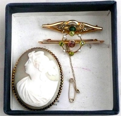 Lot 82 - A cameo brooch, a peridot and seed pearl set brooch and another