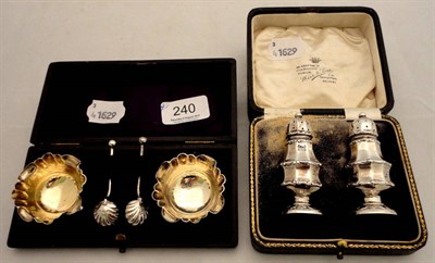 Lot 240 - A pair of silver salts and spoons - cased and a pair of silver pepperettes - cased