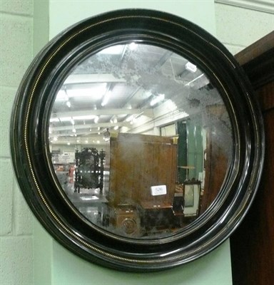 Lot 526 - Circular convex wall mirror in an ebonised frame