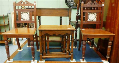 Lot 535 - A nest of three oak occasional tables and a pair of chairs with tile inserts to the back