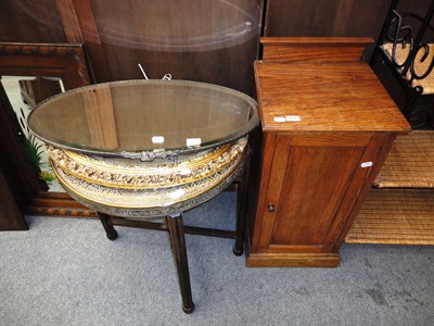 Lot 691 - Two oval wall mirrors, a brass mounted circular table top on folding stand and an oak pot cupboard