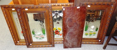 Lot 692 - A set of four oak framed mirrors with reverse painted decoration and a carved panel