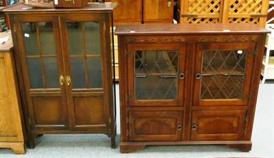 Lot 695 - A reproduction oak four door cabinet with leaded glass cabinet and an oak two door glazed bookcase