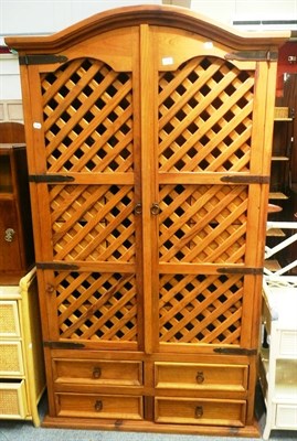 Lot 699 - A modern pine two door cupboard with lattice doors