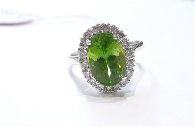 Lot 71 - A 14ct white gold peridot and diamond cluster ring